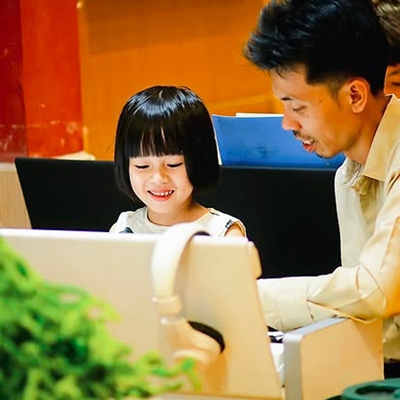 Bé gái cười tươi bên thầy giáo trong giờ học